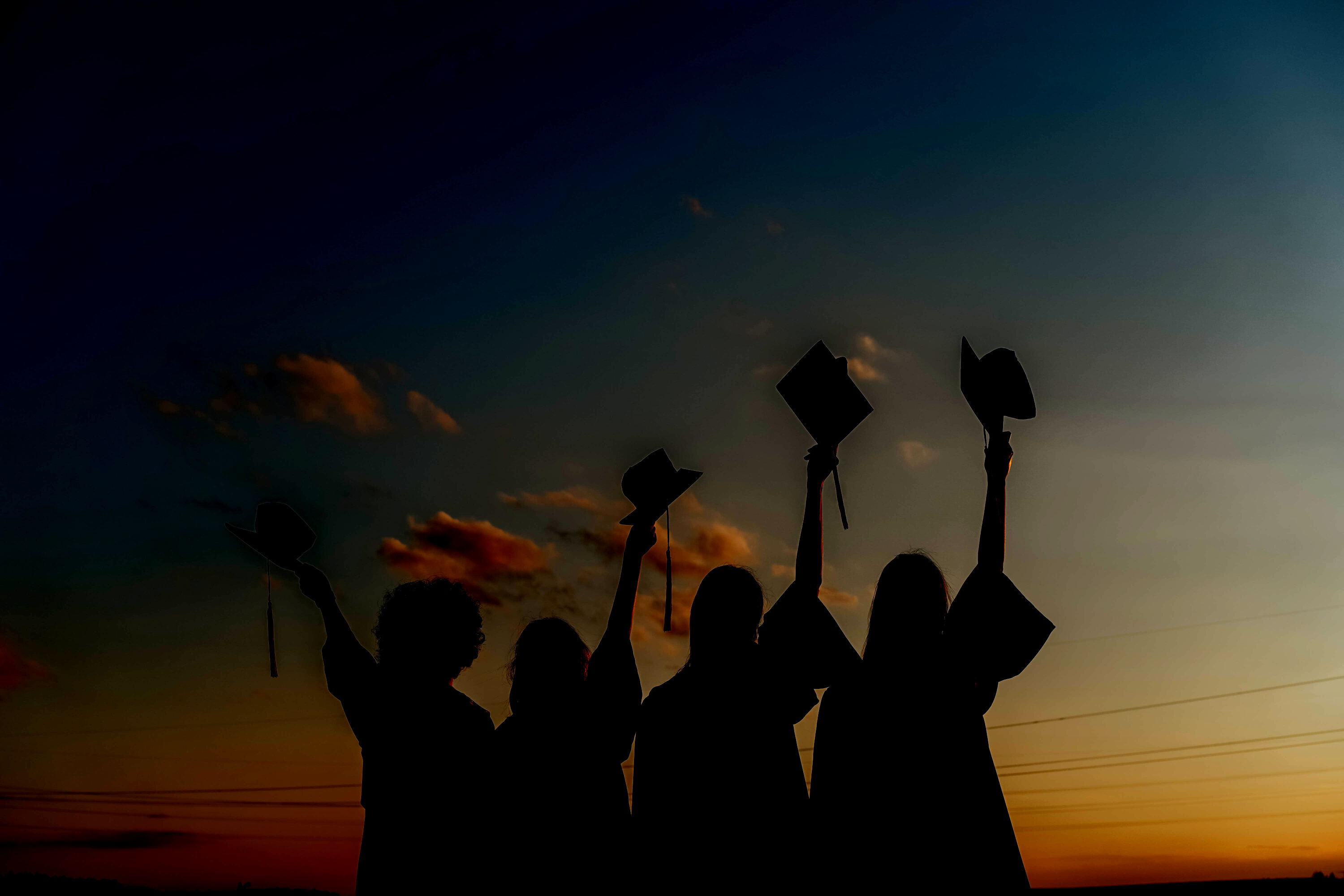 Silhouette of People Raising Their Graduation Hats