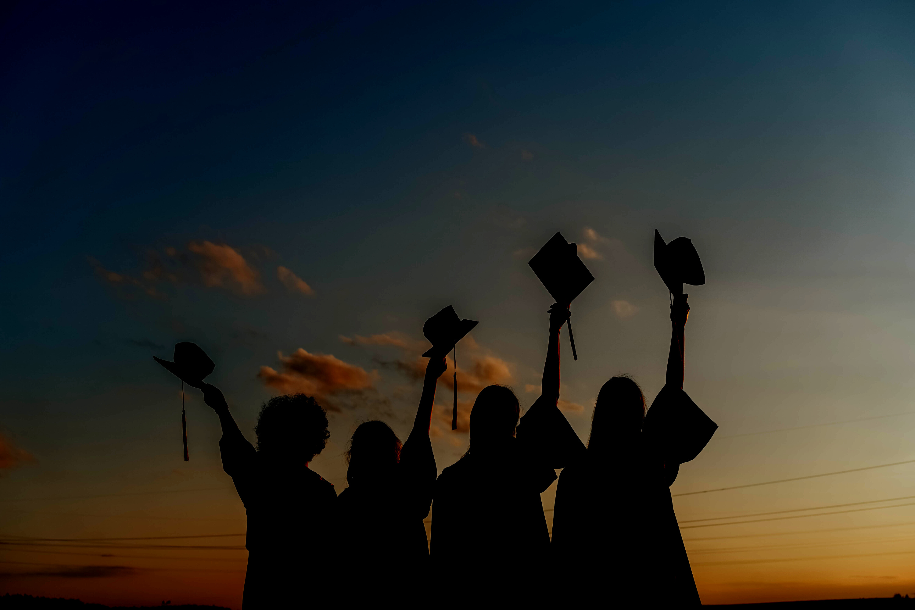 Silhouette of People Raising Their Graduation Hats